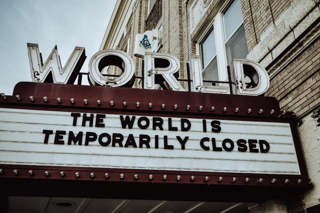 Foto eines Kino-Marquees mit der Aufschrift „The world is temporarily closed“ – Symbolbild für Pandemie, Lockdown und den Wandel in der qualitativen Marktforschung.